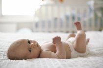 Infant baby boy lying in cot. — Stock Photo
