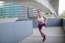 Young woman running in urban scene. — Stock Photo