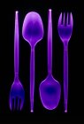 Cucharas y tenedores de plástico violeta sobre fondo negro . - foto de stock