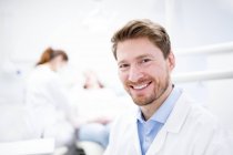 Retrato de médio adulto dentista masculino na clínica . — Fotografia de Stock