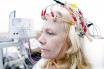Mujer rubia madura sometida a monitoreo de electroencefalografía . - foto de stock