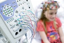 Nahaufnahme einer Elektroenzephalographie-Maschine mit einem Mädchen, das sich einer Überwachung unterzieht. — Stockfoto