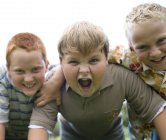 Retrato de niños gritando y sonriendo al aire libre . - foto de stock