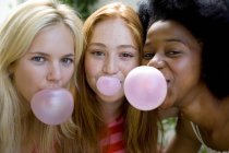 Portrait of teenage girls blowing bubblegums. — Stock Photo