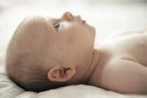 Infant baby boy lying down on bed. — Stock Photo