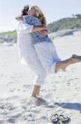 Casal maduro abraçando casal na praia . — Fotografia de Stock