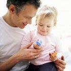 Father playing with toddler daughter on lap. — Stock Photo