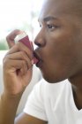Retrato do homem usando inalador de asma . — Fotografia de Stock