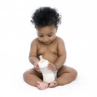 Bambina con bottiglia di latte in mano . — Foto stock