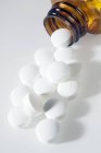 Pílulas de aspirina a sair da garrafa, close-up . — Fotografia de Stock