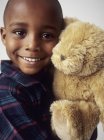 Preschooler boy in pajamas embracing teddy bear. — Stock Photo
