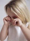 Crying preschooler blonde girl rubbing eyes. — Stock Photo