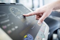 Close-up of male hand pushing control panel button of exercise machine. — Stock Photo