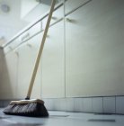 Broom leaning on kitchen counter, low angle view. — Stock Photo
