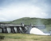 Acqua che fuoriesce dalla base della diga nella centrale idroelettrica di Perthshire, Scozia — Foto stock