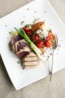 Healthy meal of char-grilled tuna, roast tomatoes and goat cheese salad. — Stock Photo