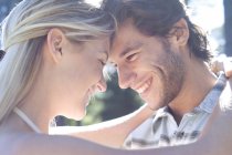Young couple embracing outdoors in soft sunlight. — Stock Photo