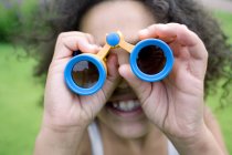 Afro-caribbean girl using binoculars in park. — Stock Photo