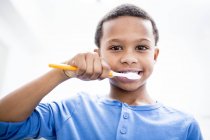 Retrato de menino escovando dentes no fundo branco . — Fotografia de Stock