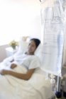 Teenage girl receiving intravenous therapy with drip in hospital ward. — Stock Photo