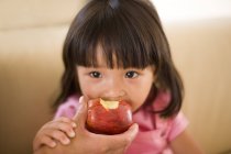 Femme main tenant pomme et nourrissant tout-petit fille . — Photo de stock