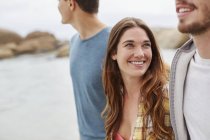 Young woman smiling and looking at male friend. — Stock Photo
