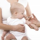 Cropped view of nurse making vaccination to baby in mother hands. — Stock Photo