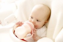 Девочка пьет молоко из бутылки. — стоковое фото