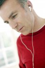 Hombre escuchando música a través de auriculares . - foto de stock