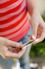 Cropped view of teenage girl preparing cigarette made with tobacco and cannabis. — Stock Photo