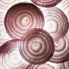 Close-up view of red onion slices on white background. — Stock Photo