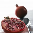 Close-up view of halved and whole pomegranates. — Stock Photo