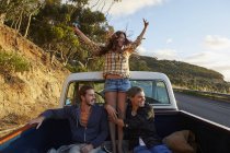 Friends riding in pick up truck with arms outstretched. — Stock Photo