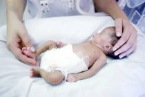 Primer plano de la enfermera que sostiene al bebé prematuro . - foto de stock
