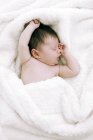 Новорожденная девочка, лежащая на белом одеяле . — стоковое фото
