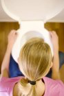 Vue aérienne de la jeune femme accroupie sur la cuvette des toilettes . — Photo de stock