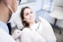 Zahnarzt hält Spritze mit Patient in Zahnklinik. — Stockfoto