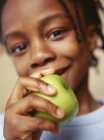 Menino da idade elementar segurando maçã verde, retrato . — Fotografia de Stock