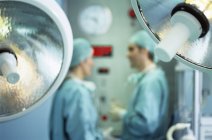 Operationslampen im Operationssaal mit Chirurgen im Hintergrund. — Stockfoto