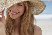 Portrait de femme portant un chapeau de soleil sur la plage . — Photo de stock
