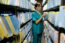 Nurse checking medical records in store room. — Stock Photo