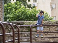 Giovane birdwatcher con binocolo sulla strada . — Foto stock