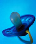 Pacifier on blue background, close-up. — Stock Photo