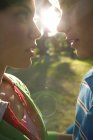 Young couple in love leaning to kiss in soft sun light. — Stock Photo