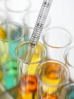 Close-up of pipetting colorful liquids into test tubes. — Stock Photo
