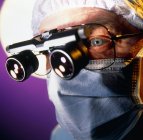 Chirurg mit mikrochirurgischen Vergrößerungslinsen über der Brille. — Stockfoto