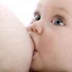 Close-up of mother breastfeeding infant baby. — Stock Photo