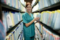 Enfermeira a verificar registos médicos na arrecadação . — Fotografia de Stock