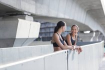 Жінки в спортивному одязі спираються на стіну — стокове фото