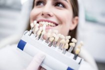 Paciente dental femenina seleccionando carillas de dientes . - foto de stock